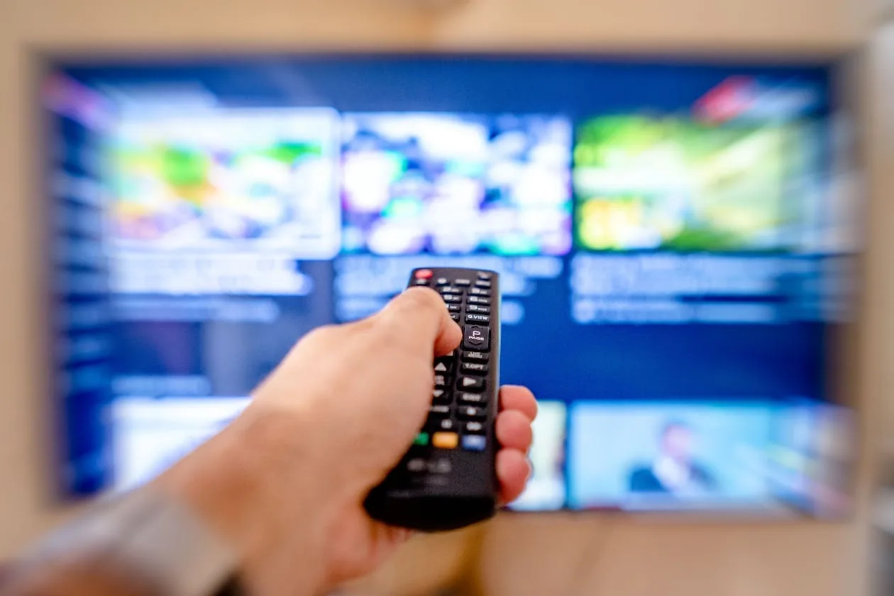 apollo group tv error codes fix - hand holding remote with streaming interface